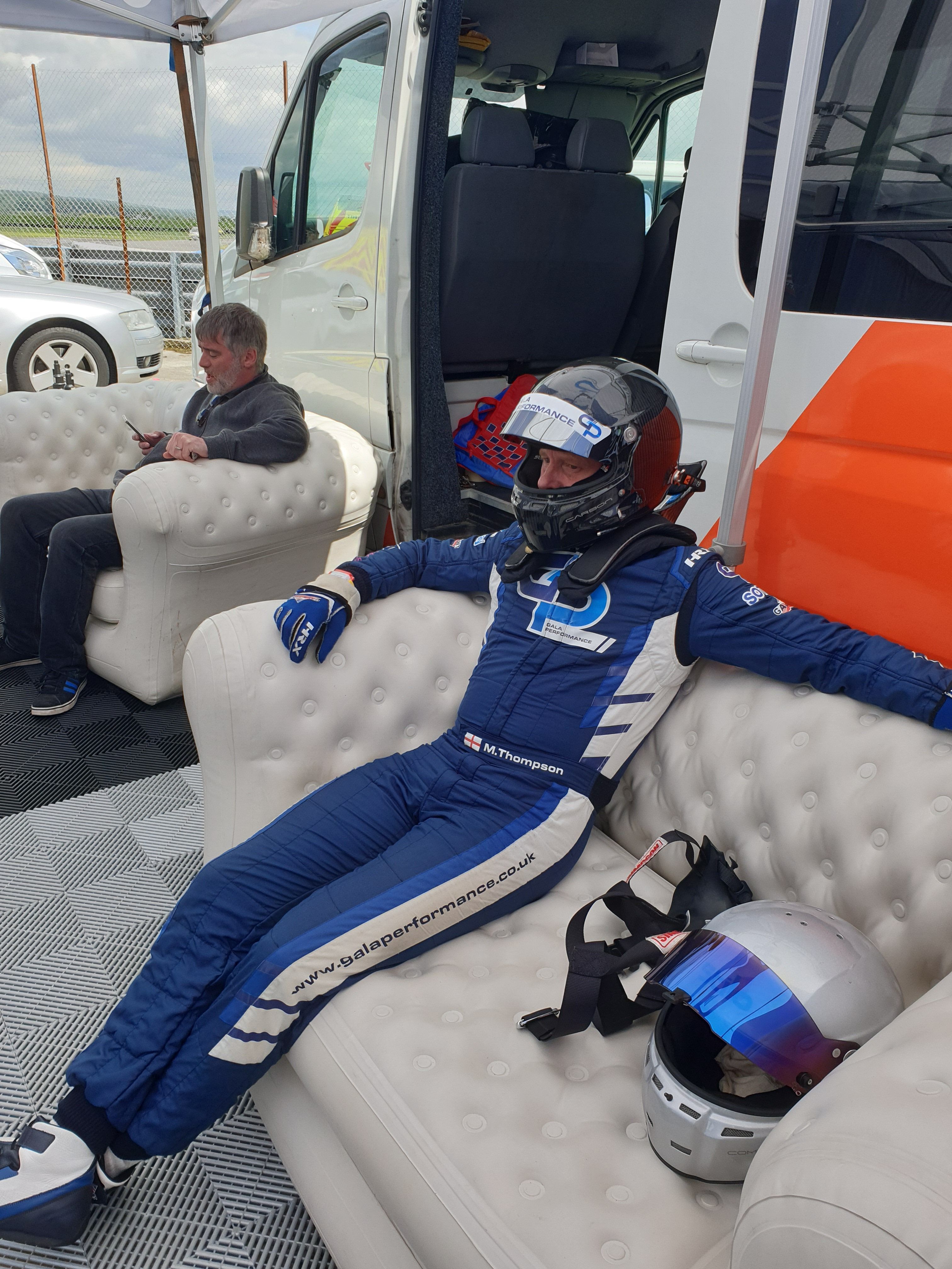 racing driver sits on a white inflatable sofa