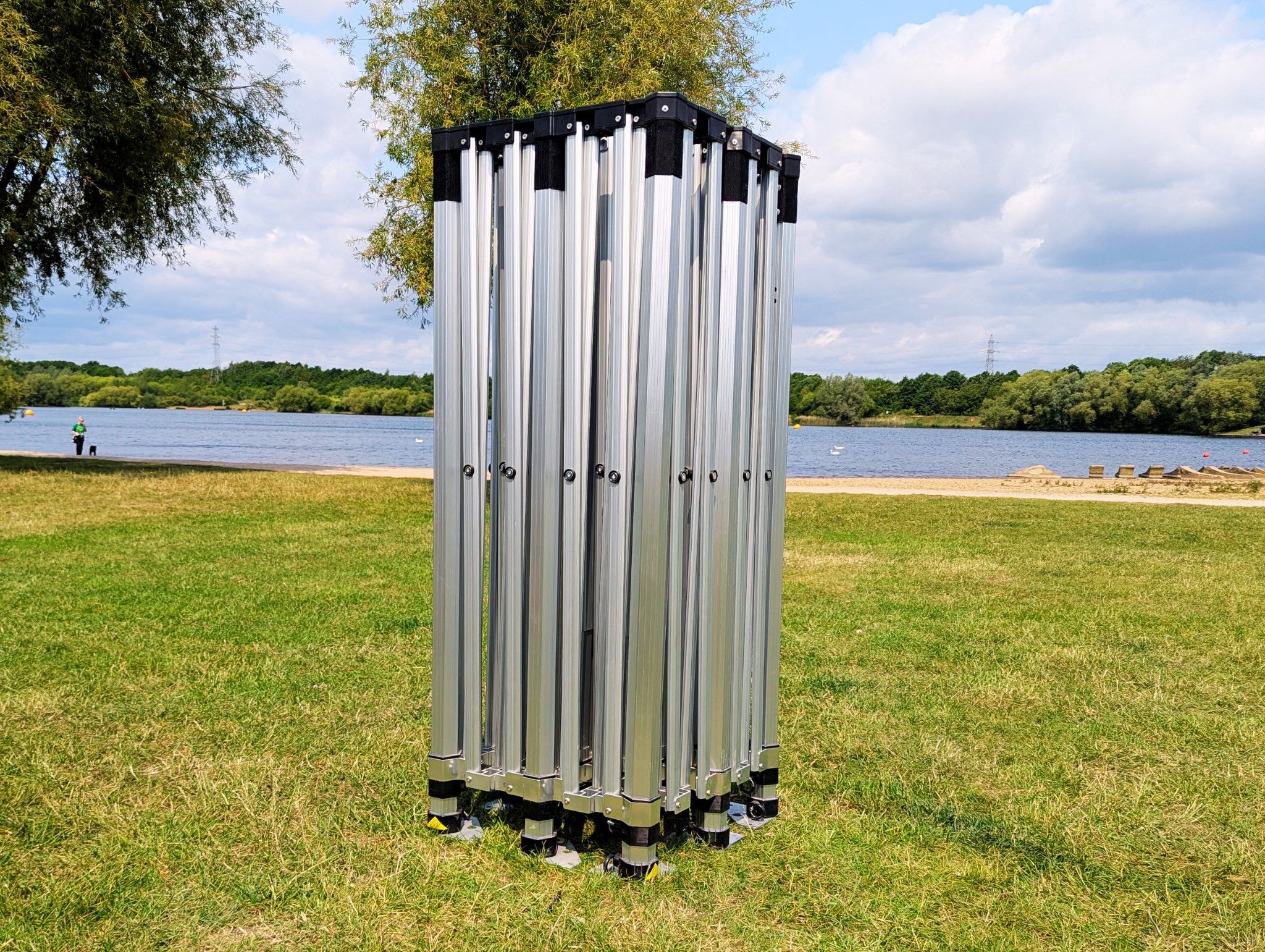 pop up marquee frame with no canopy, beside a lake