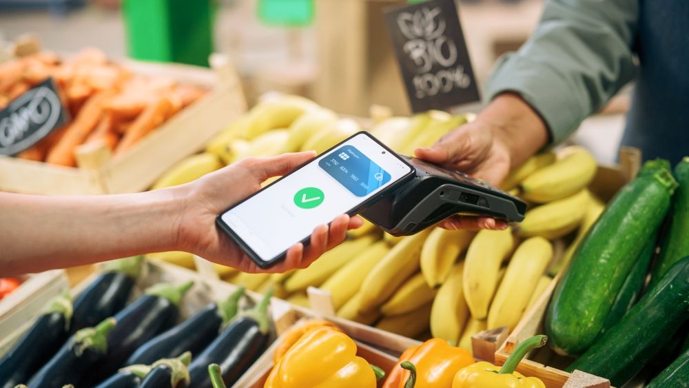 somebody makes payment at a fruit stall