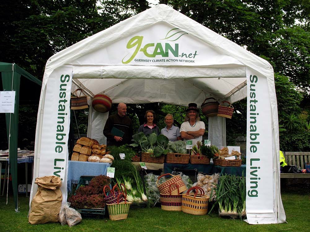 Farmers under a market stall tent