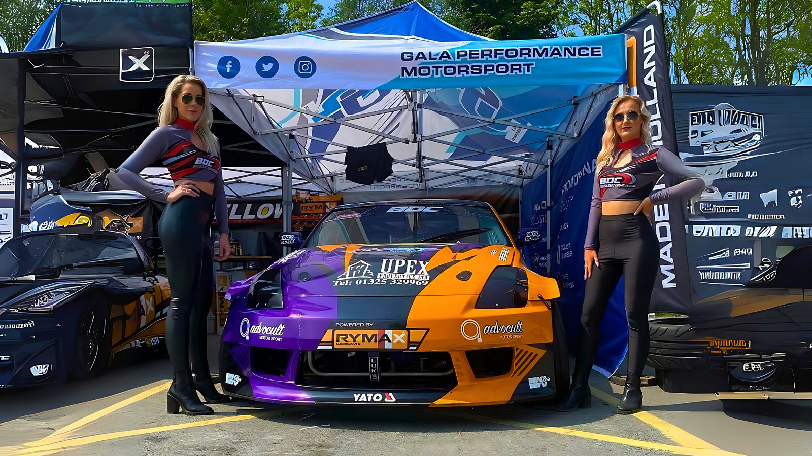 Sports car under branded gazebo