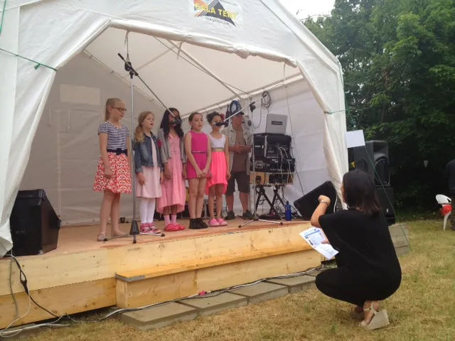 Children perform on stage beneath a Gala Tent marquee
