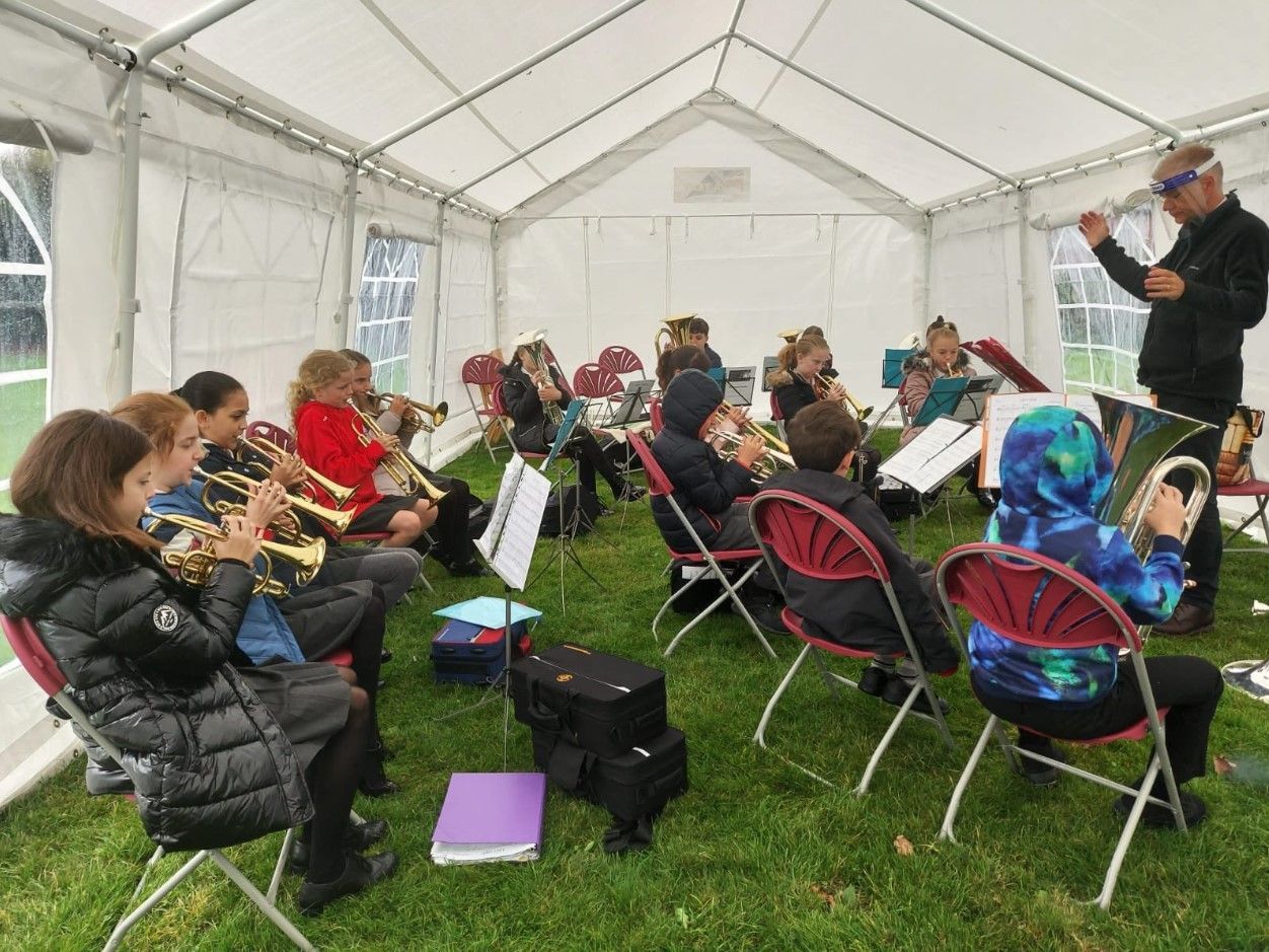 children learn music classes inside a marquee