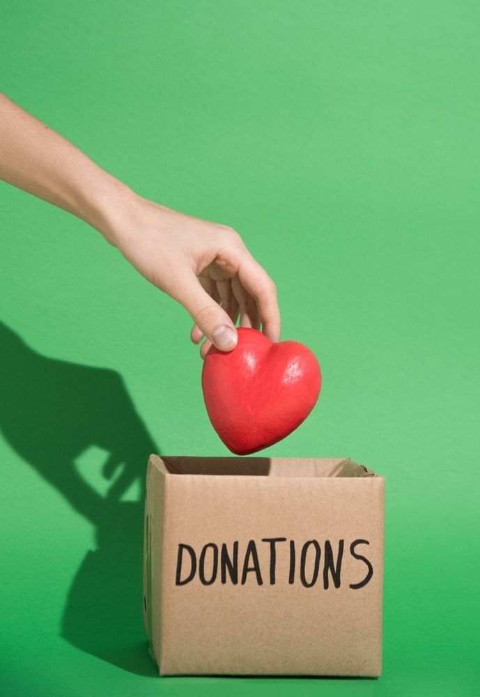 somebody dropping a heart into a box labelled "donations"