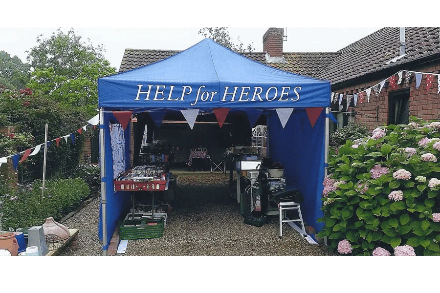 Blue gazebo in garden with Help for Heroes branding