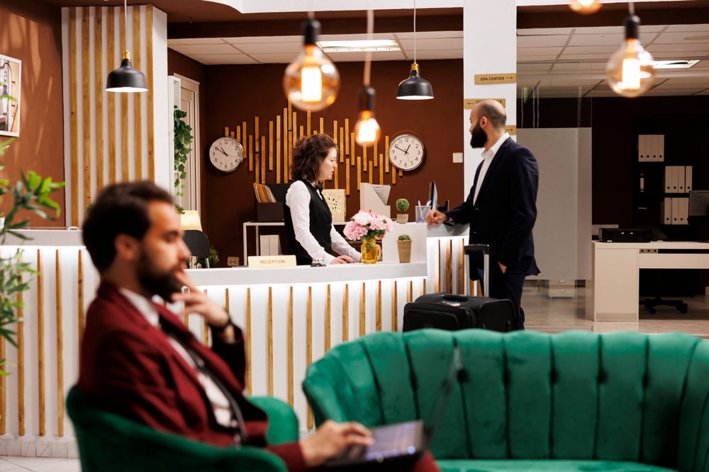 a man stands at the reception in a hotel lobby