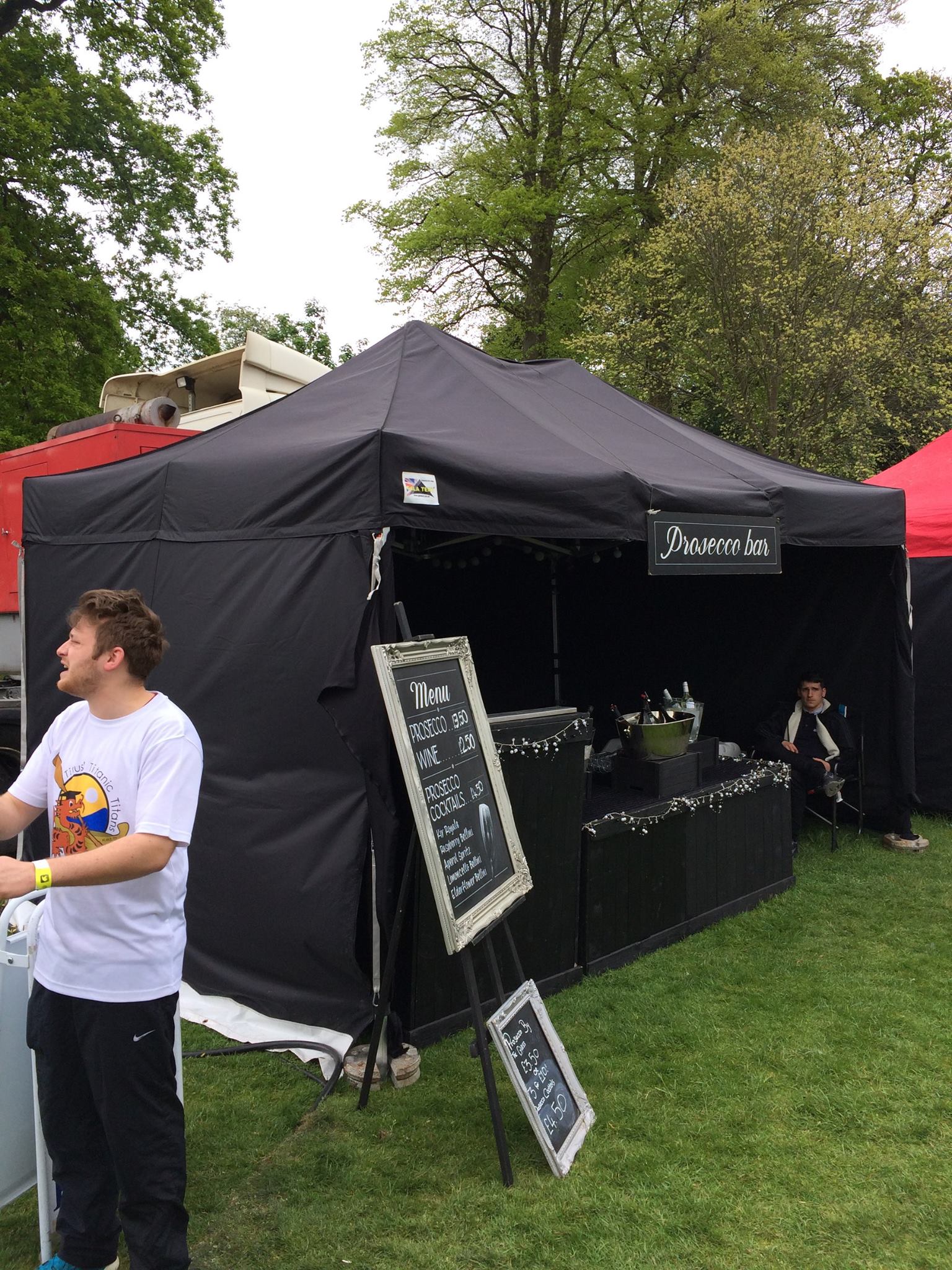a black instant gazebo is used as a drinks tent