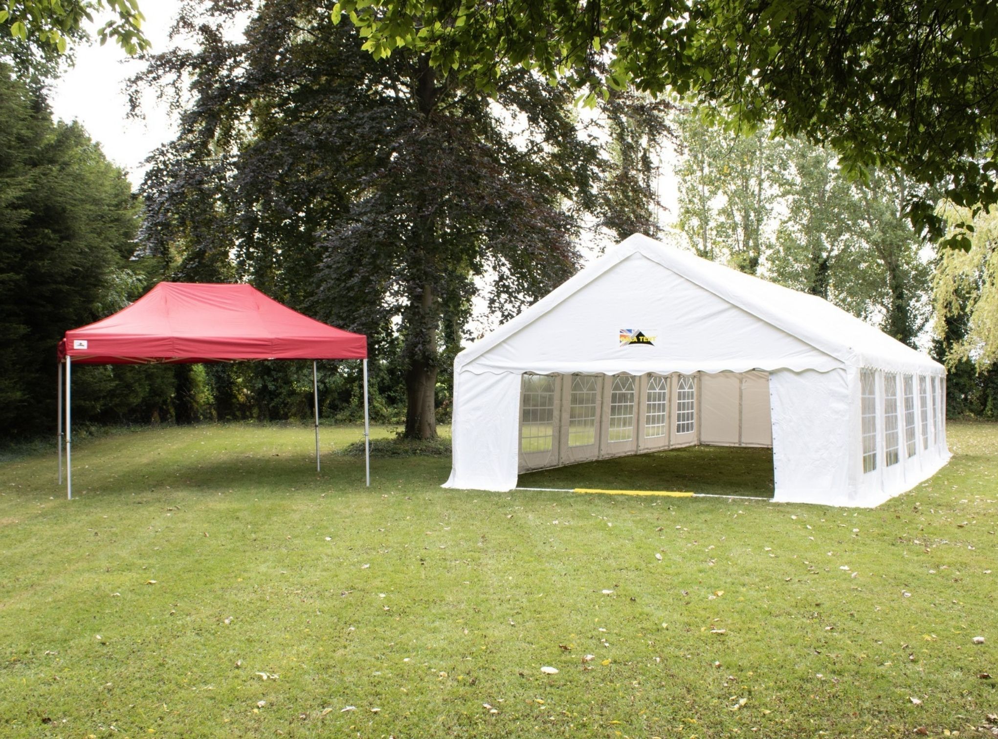 a large marquee beside a red gazebo