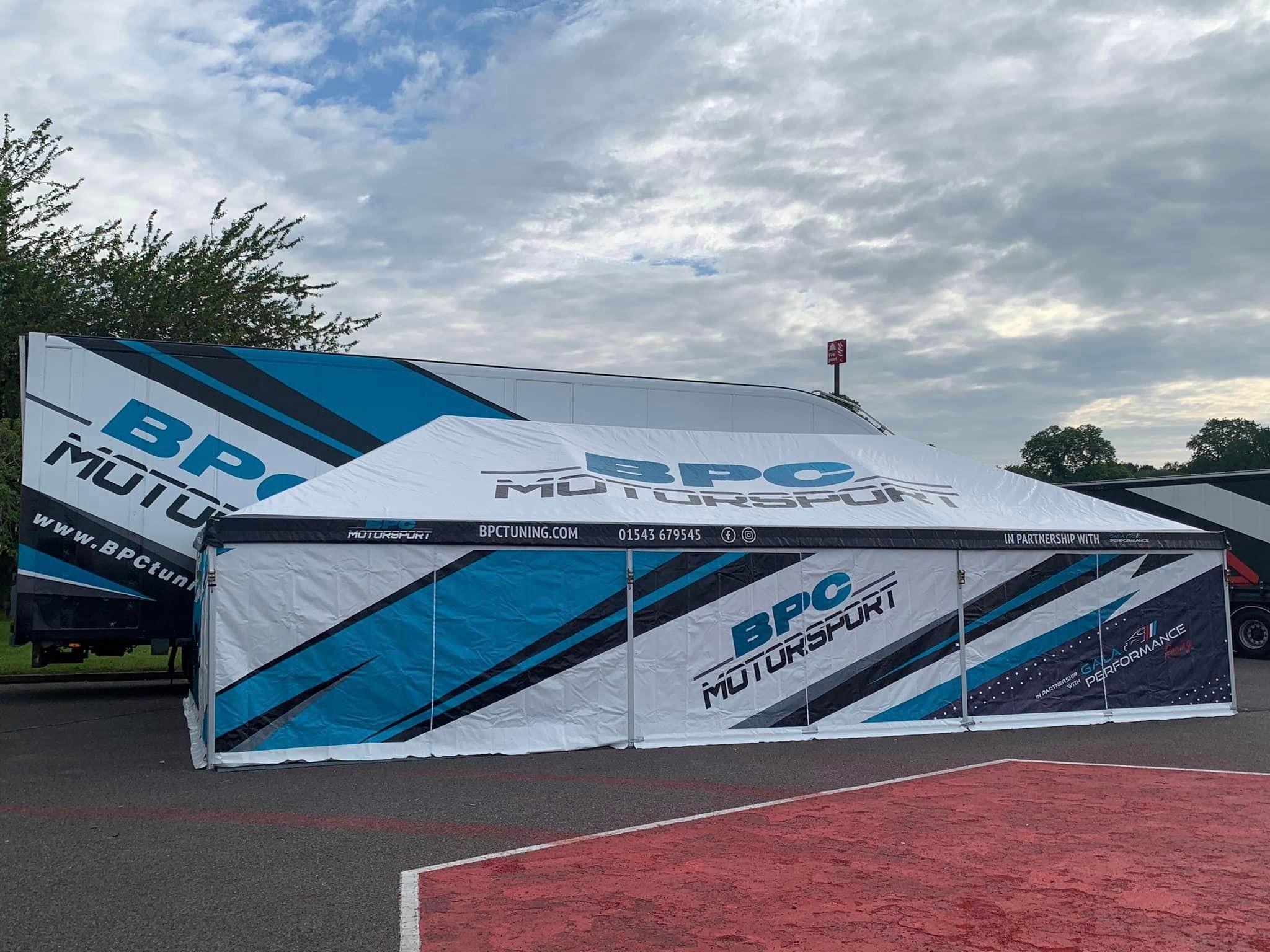 branded marquee in motorsport paddock
