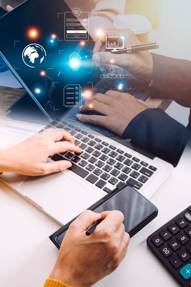 hands working on computers and smartphones with digital overlay