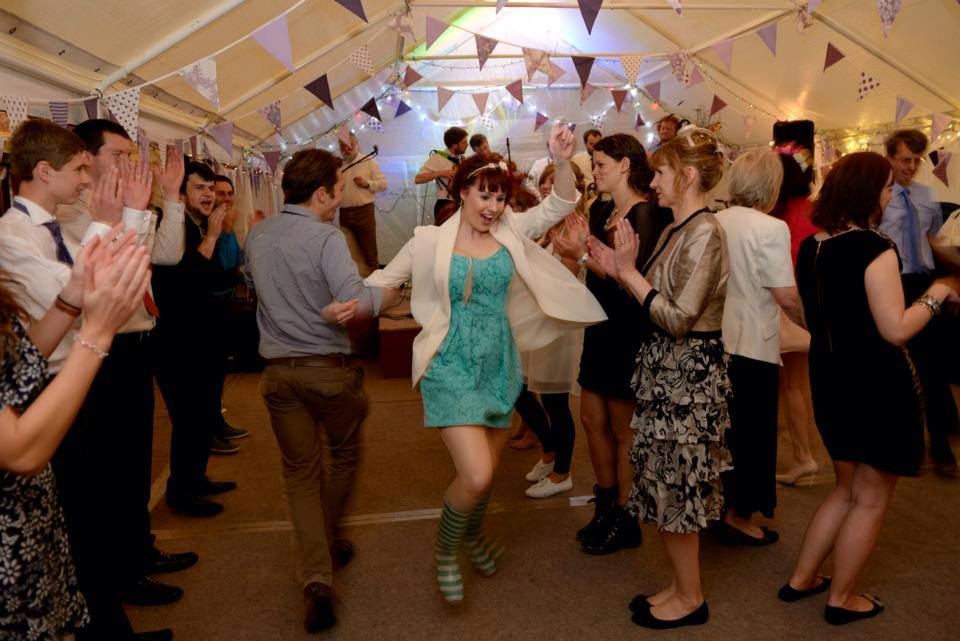 people celebrate inside a marquee