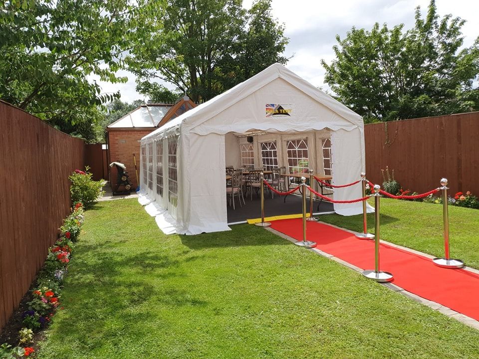 party tent with a red carpet in a grassy garden