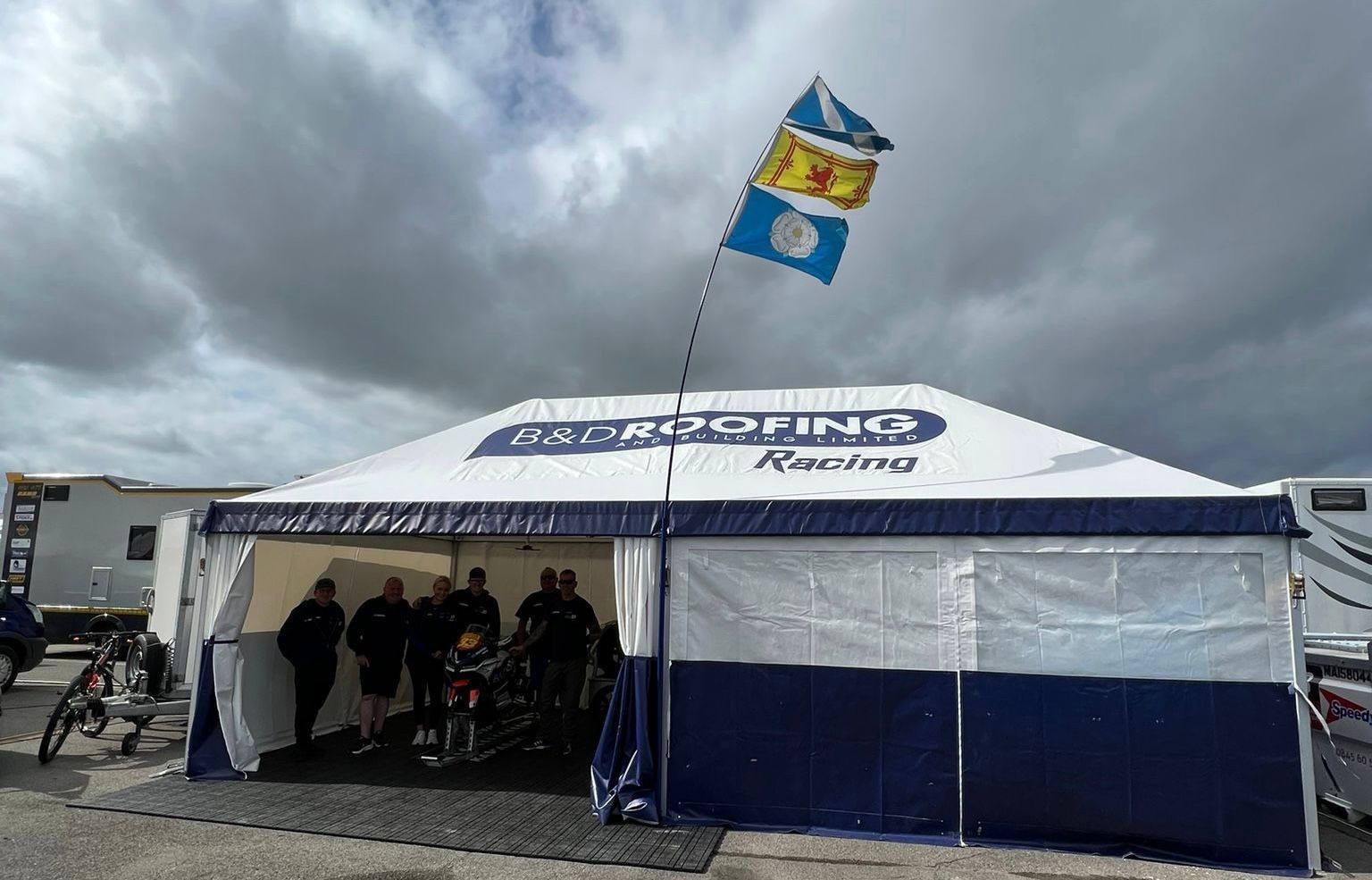 a motorcycle team inside a heavy duty motorsport awning