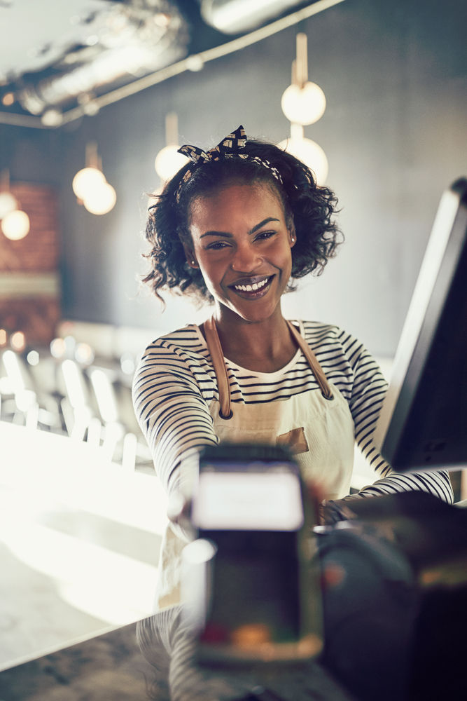 female shop assistant smiling behind the counter