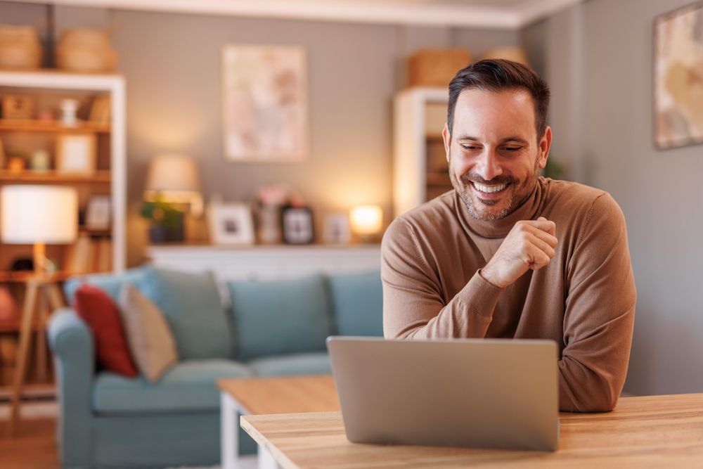 Smiling businessman looking at laptop
