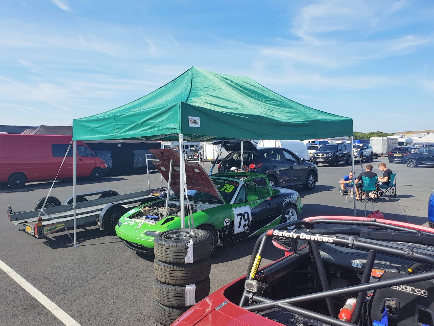 lightweight green gazebo used in a motorsport paddock