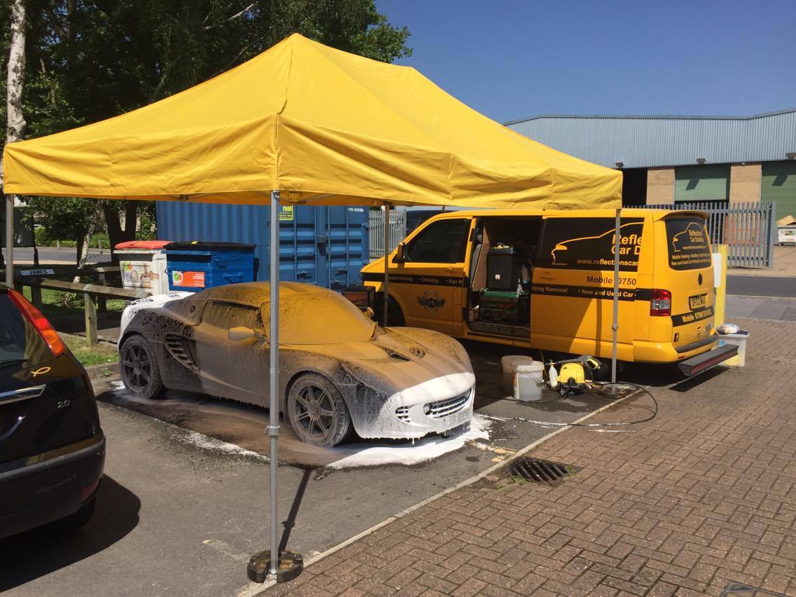 bright yellow gazebo used to shelter vehicle during valeting