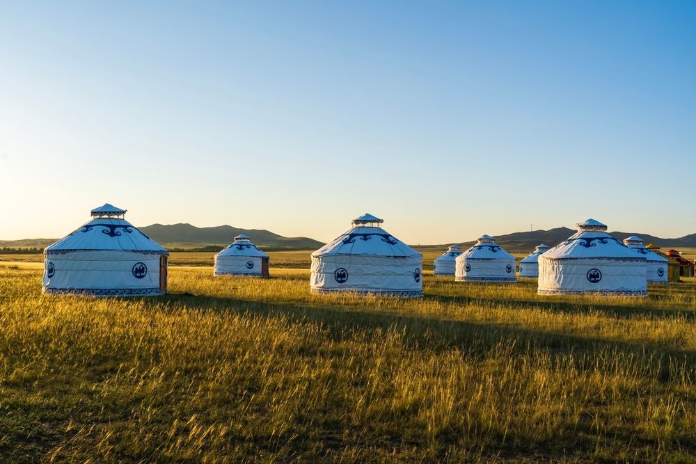 yurts in a field under blue sky