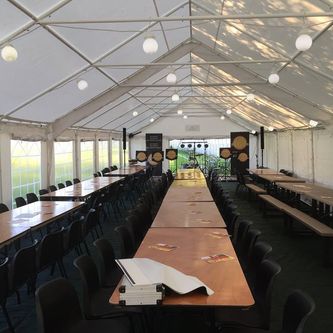 Interior view of a large Gala Tent Marquee lined with chairs and tables