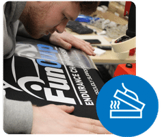 Printing technician Tom prepares a vinyl decal for heat pressing